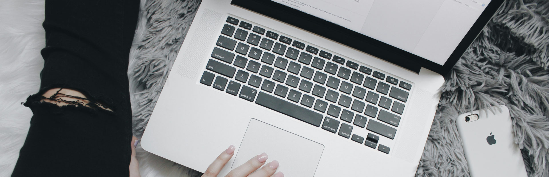 Image of a person on sitting on the floor with a new laptop